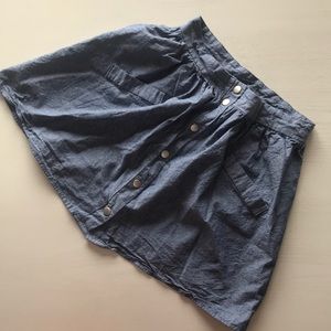 Chambray mini skirt, mid to high rise. Snap front